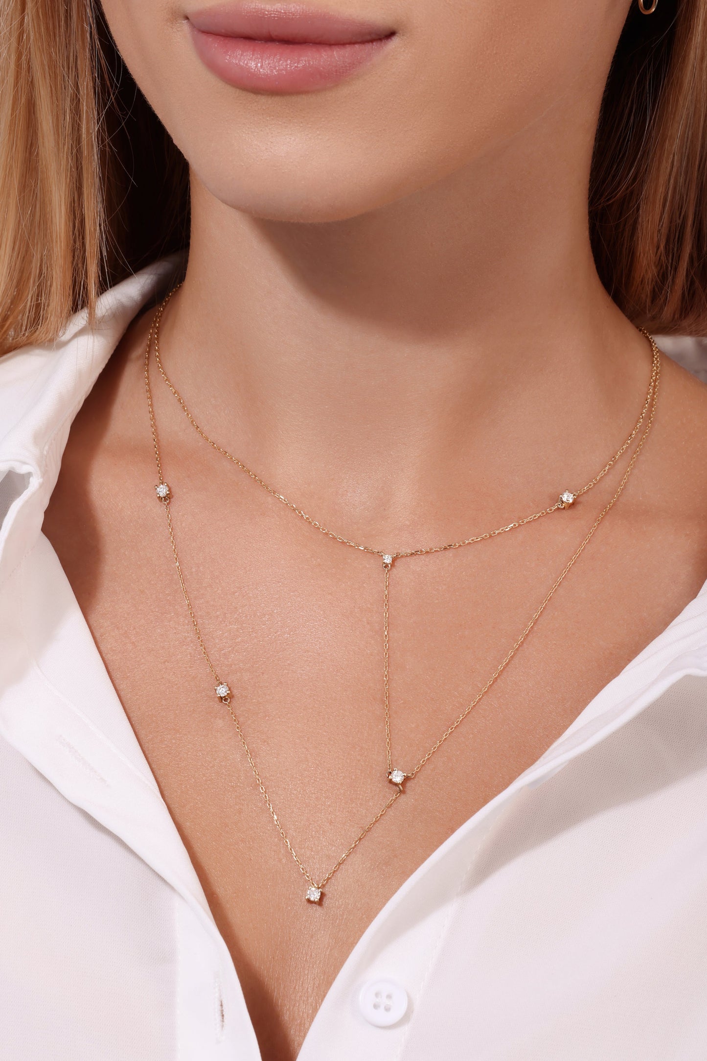 Close-up of a person wearing a delicate gold necklace with small diamonds