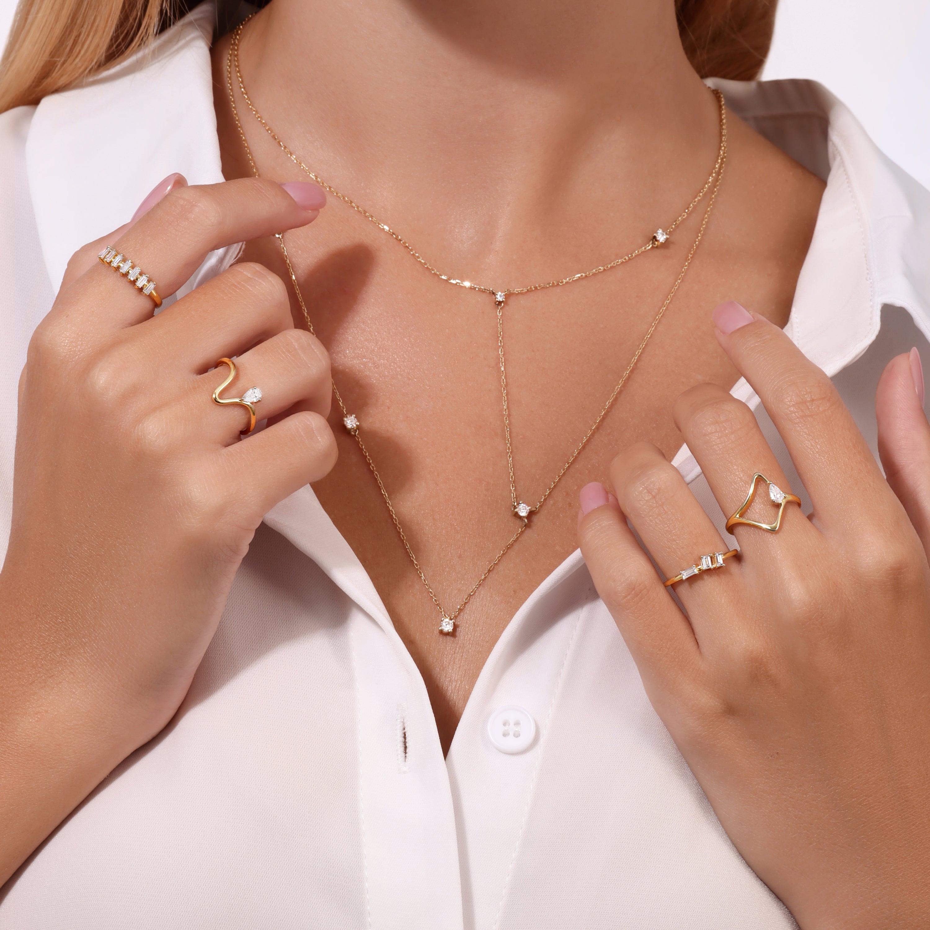 Model wearing Levi Tzeiger Jewelry layered gold necklace with round diamond accents, styled with a white shirt for a refined and minimal look