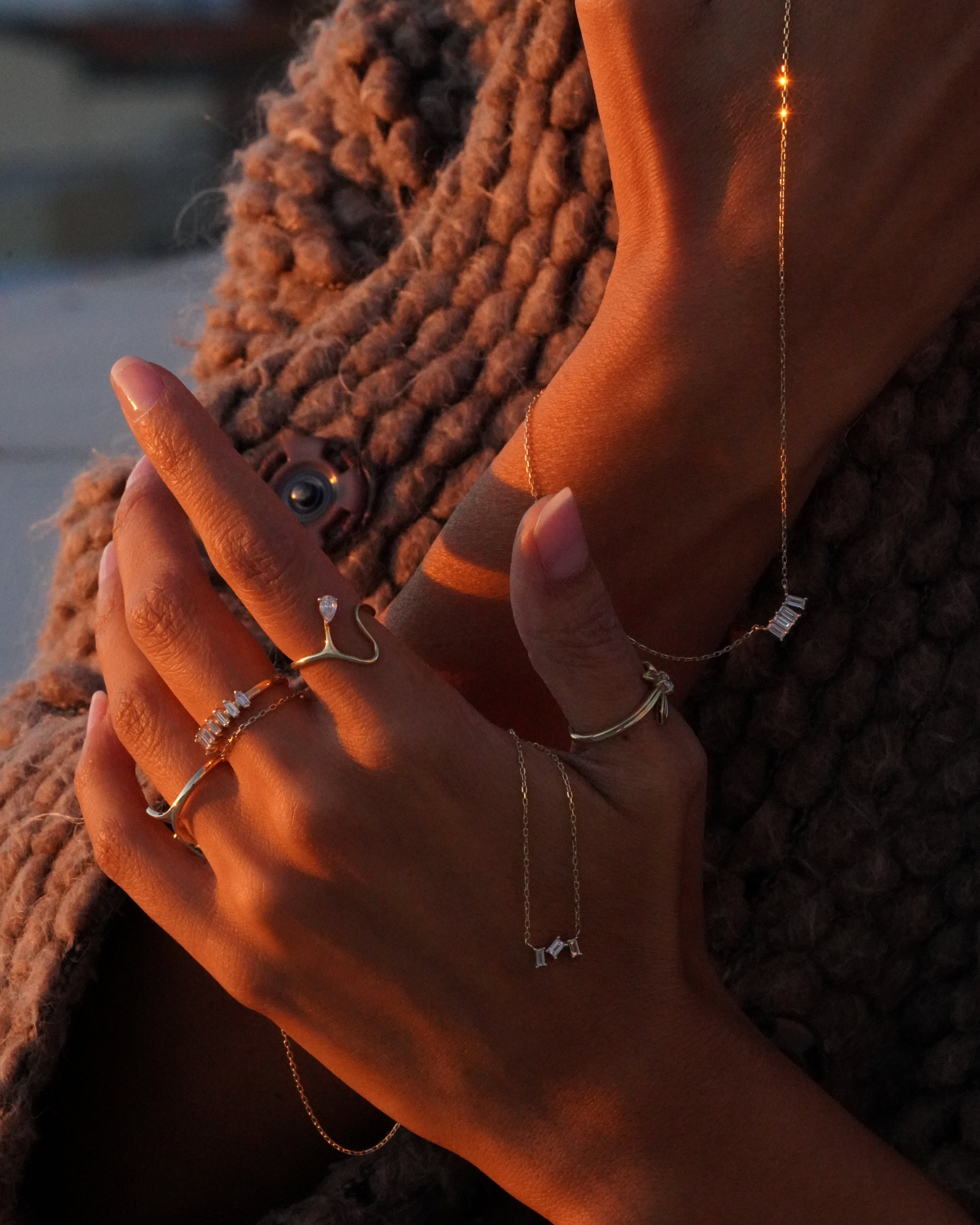 Close-up of hands with jewelry against a blurred background