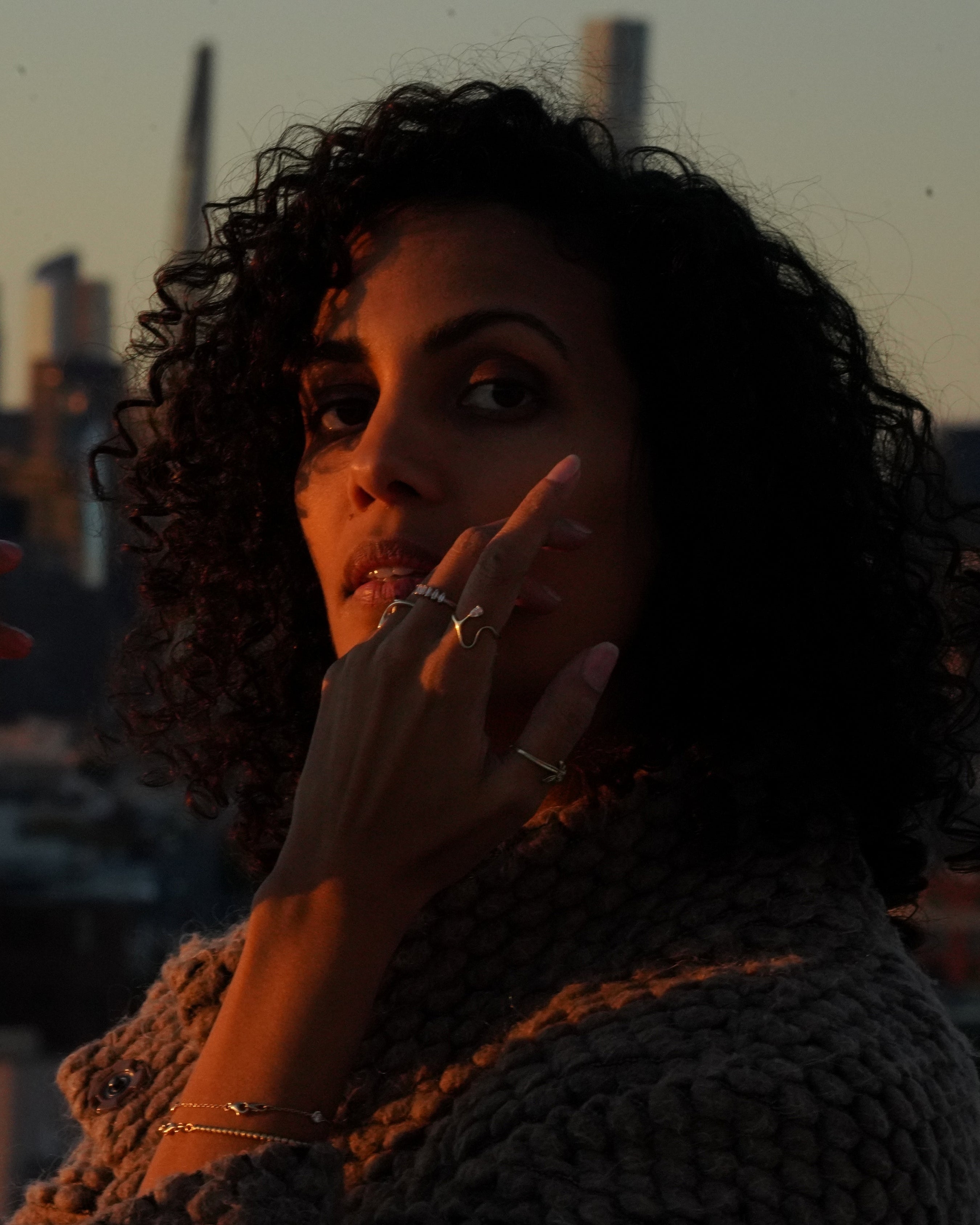 Woman with a city skyline in the background during sunset