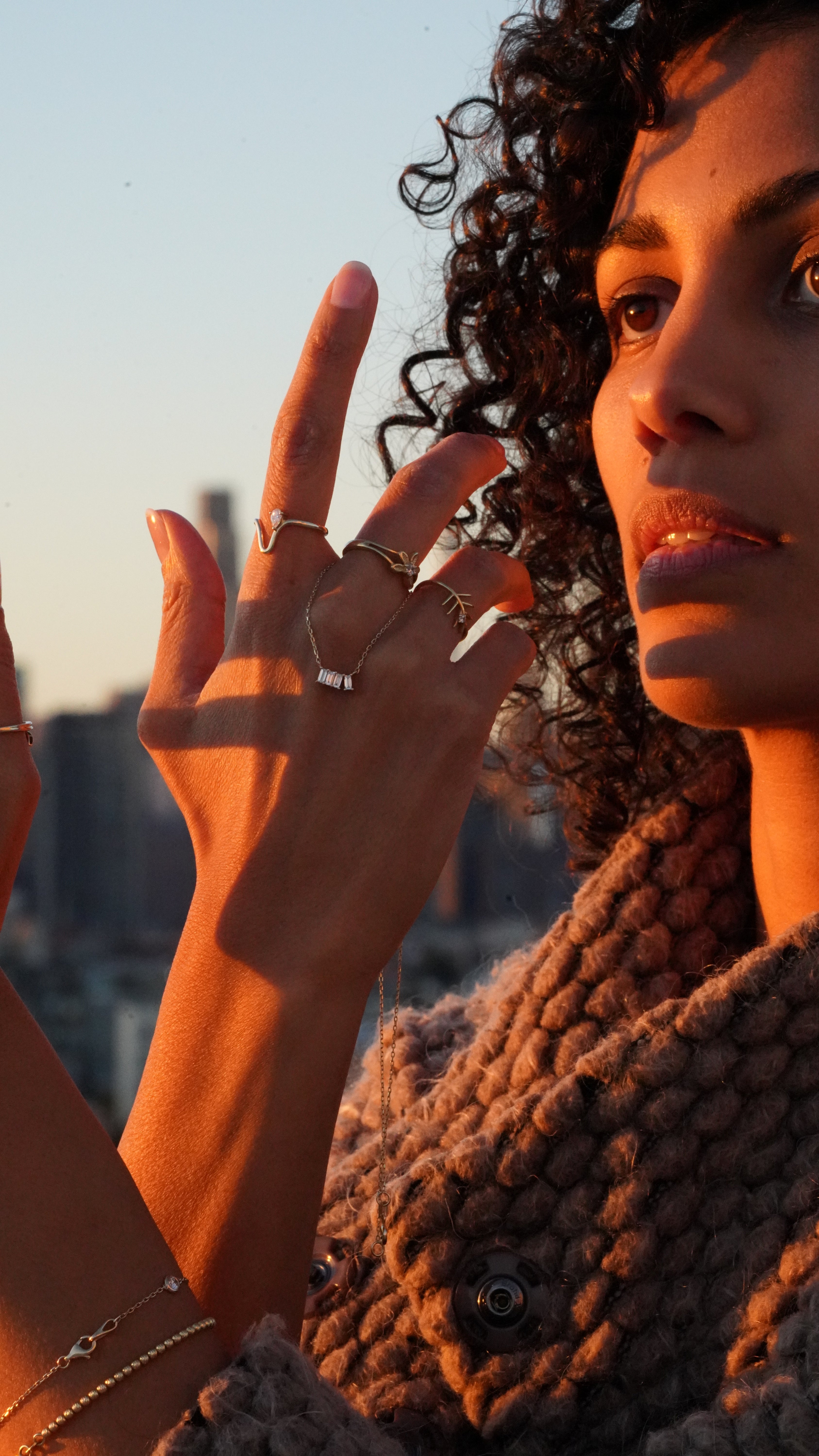 Close-up of two people's hands with rings, one person holding the other's face.