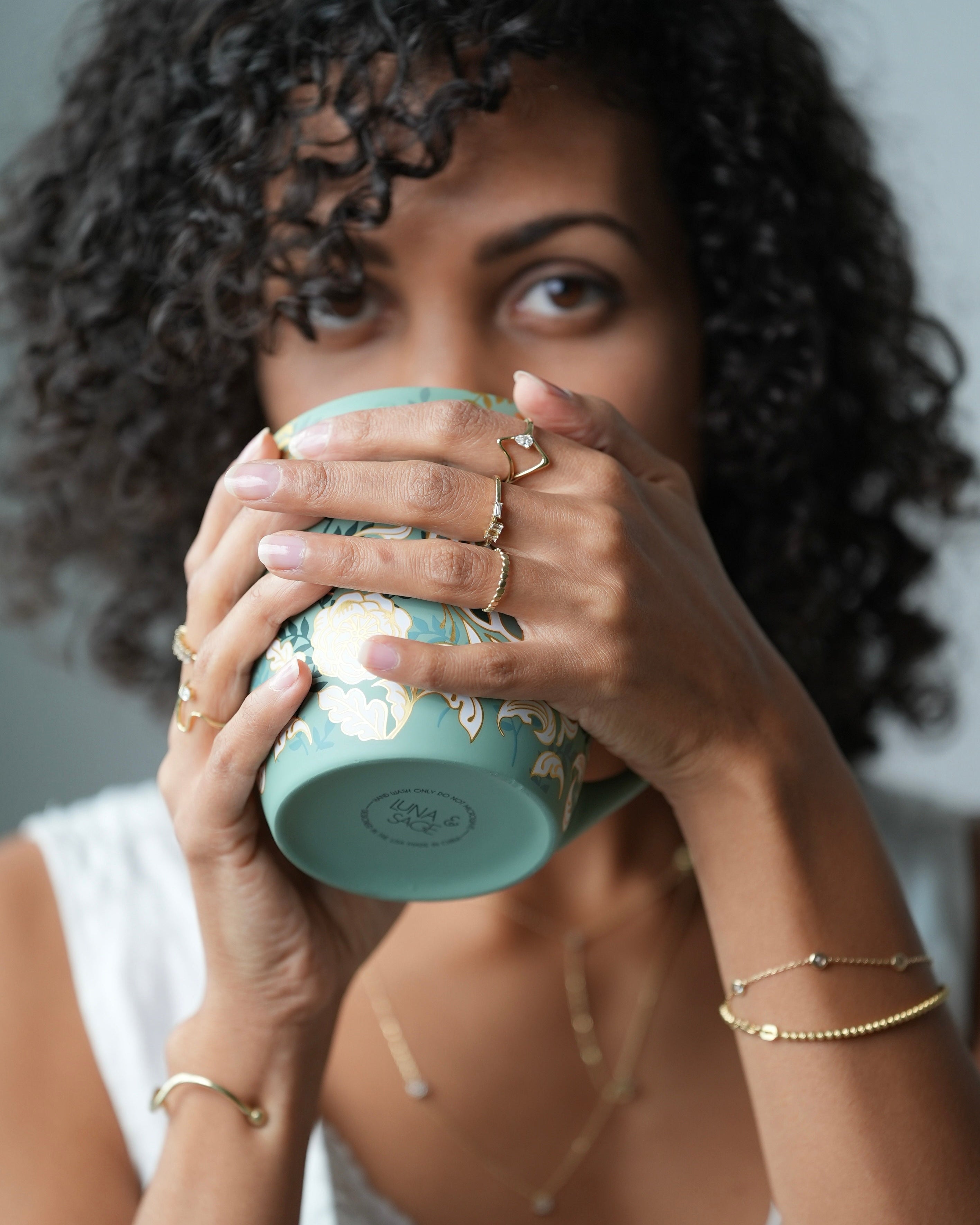 Woman holding a teal mug with a blurred background