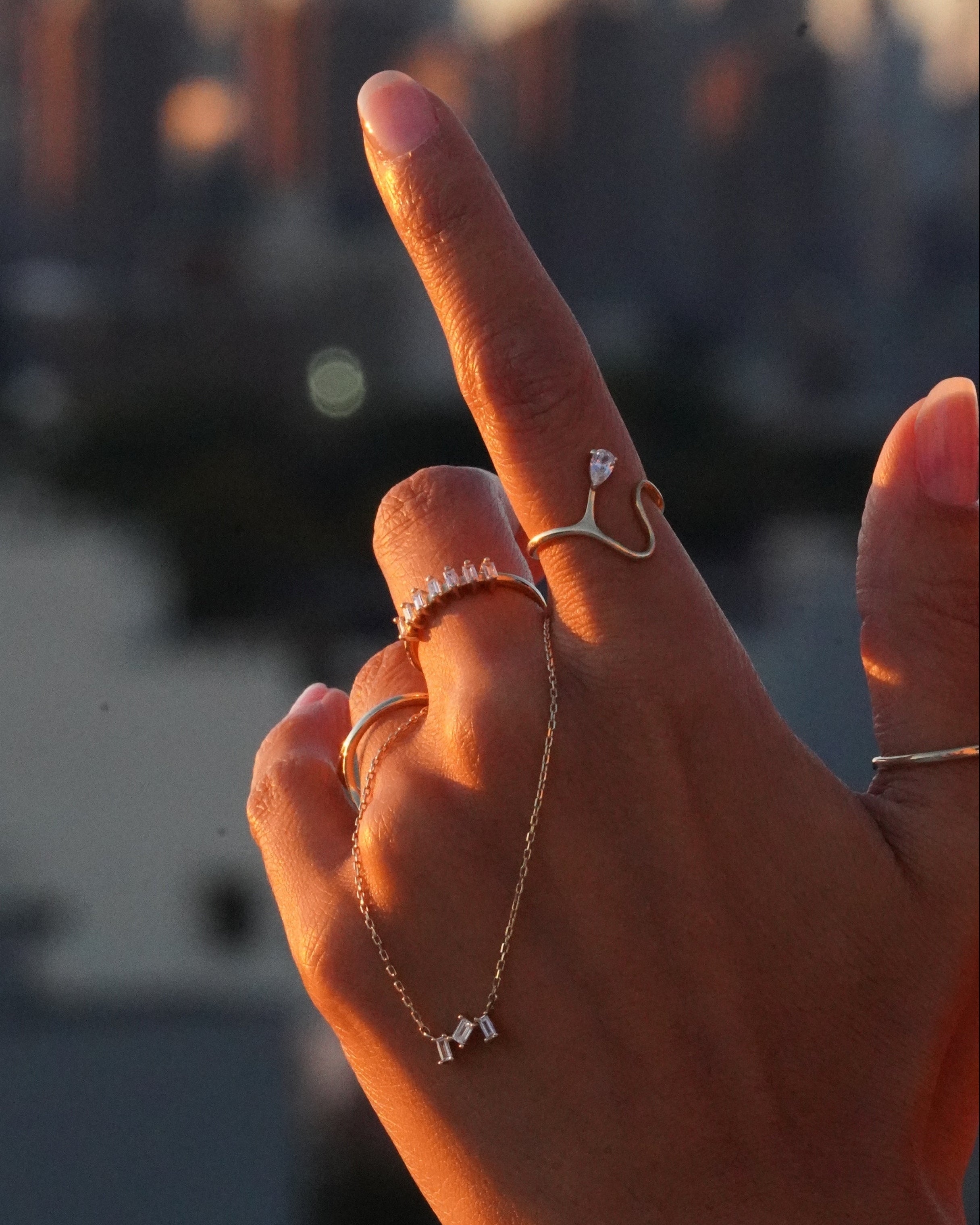Hand holding a delicate necklace with blurred background