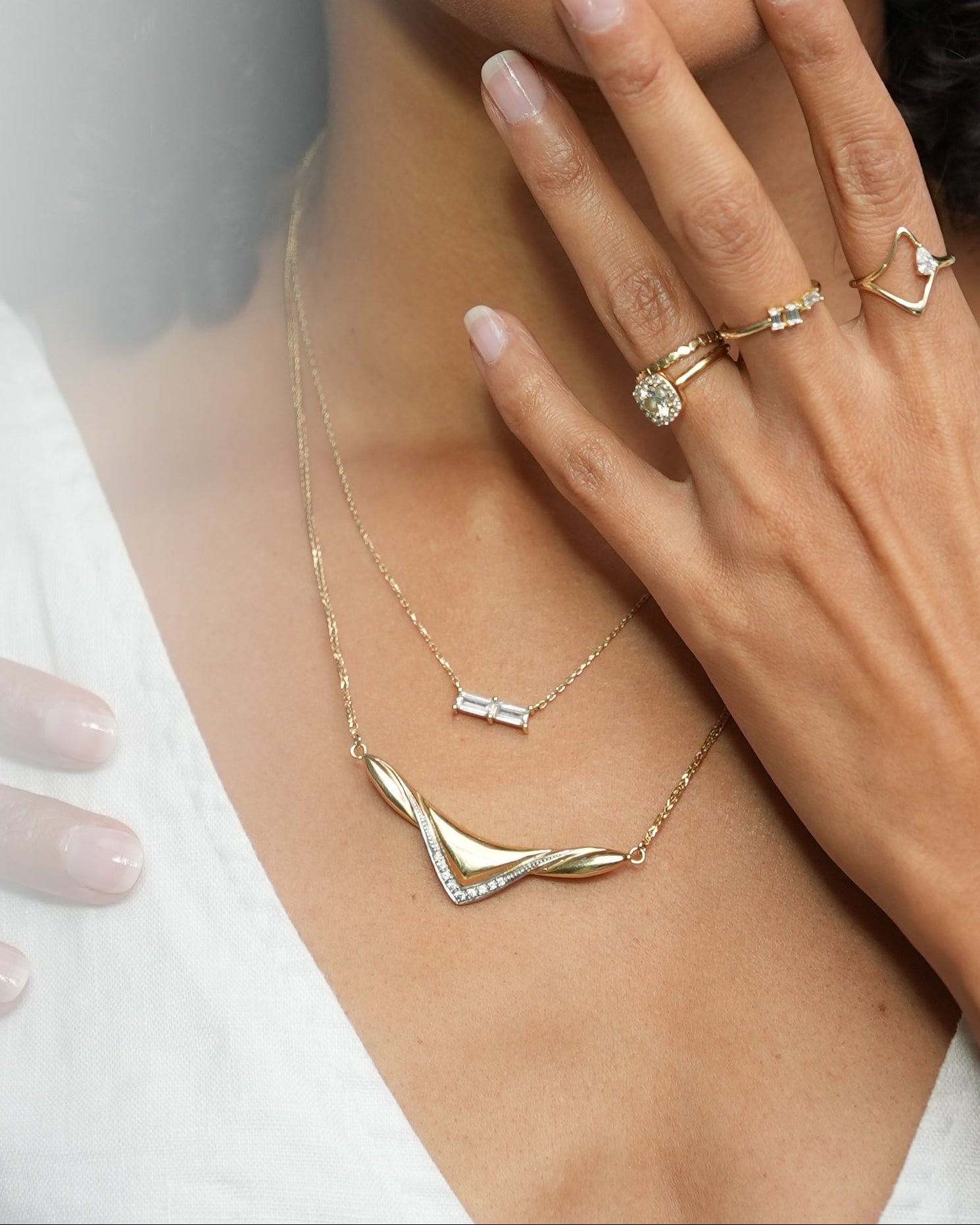 Woman with gold jewelry and a ring on a white background