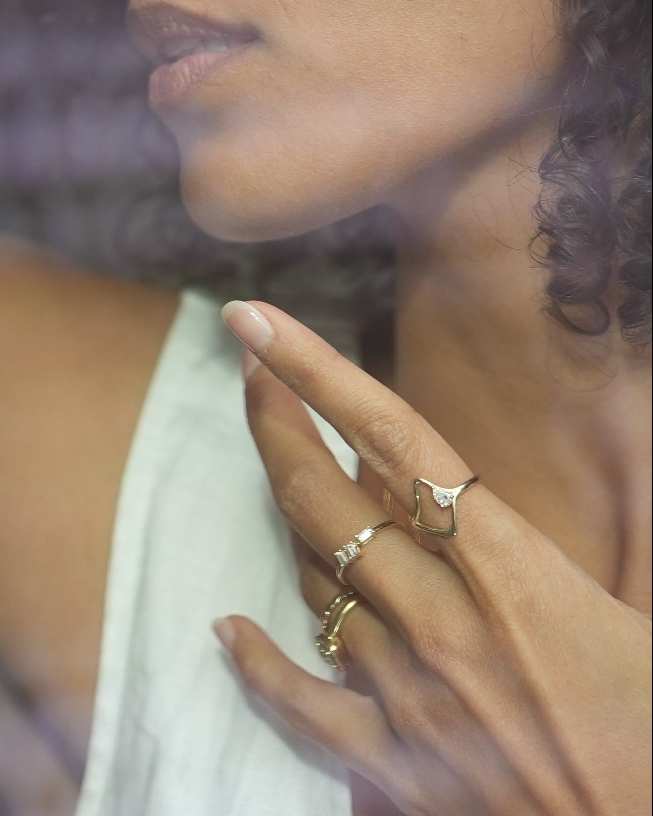 Woman with braided hair and tattoos holding her hand up to a glass surface.