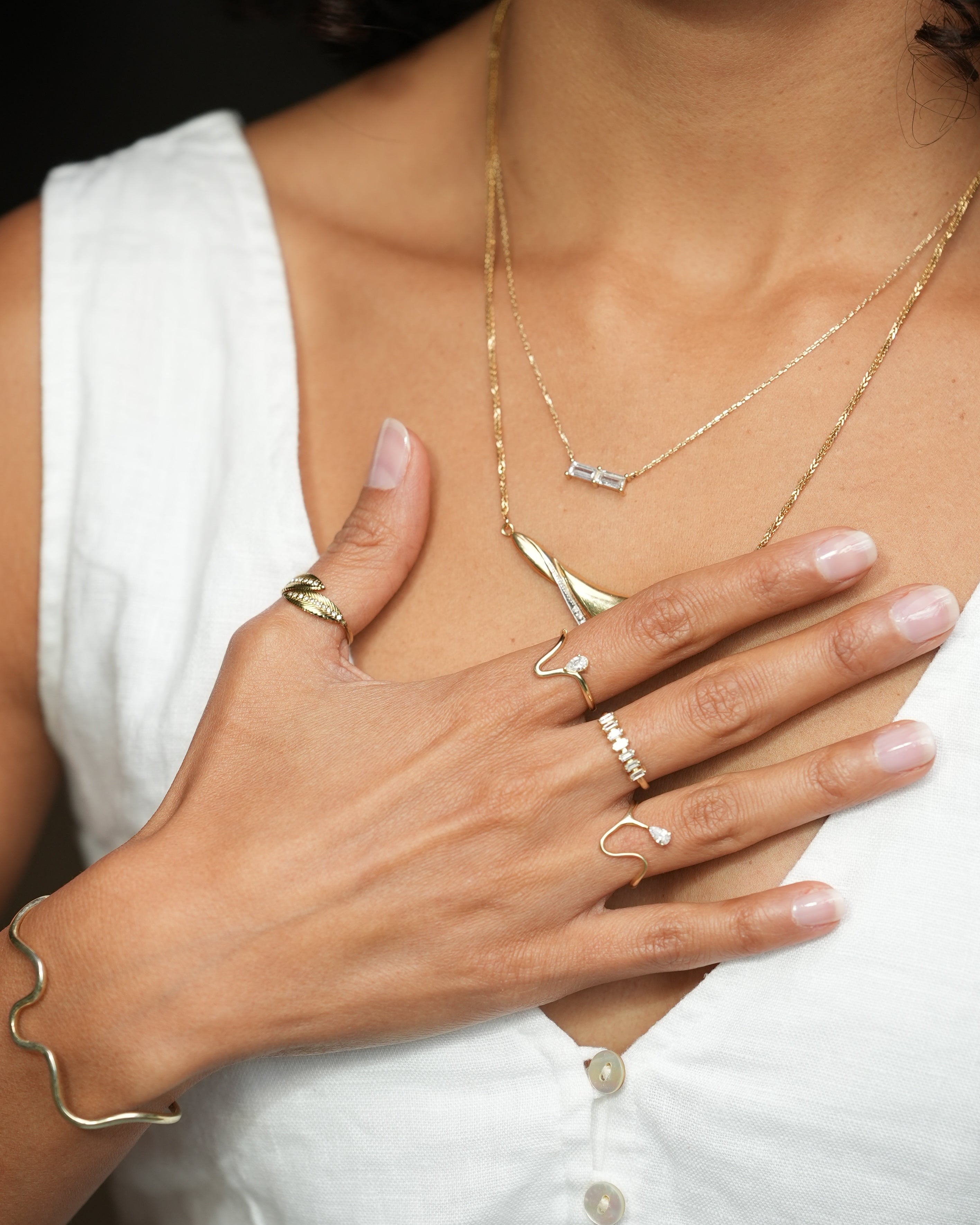 Close-up of a hand with gold jewelry on a white background
