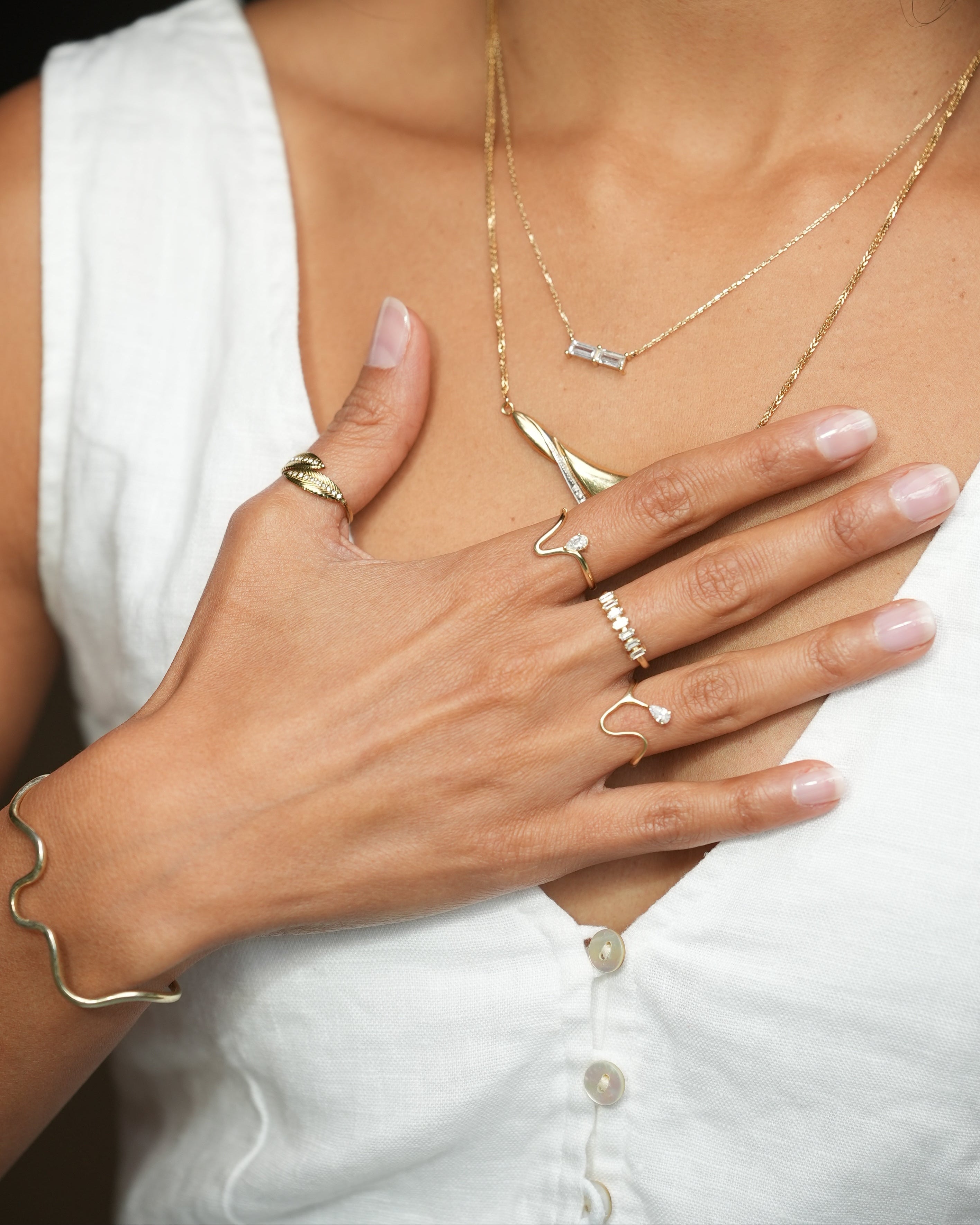 Close-up of a hand with gold jewelry on a white background