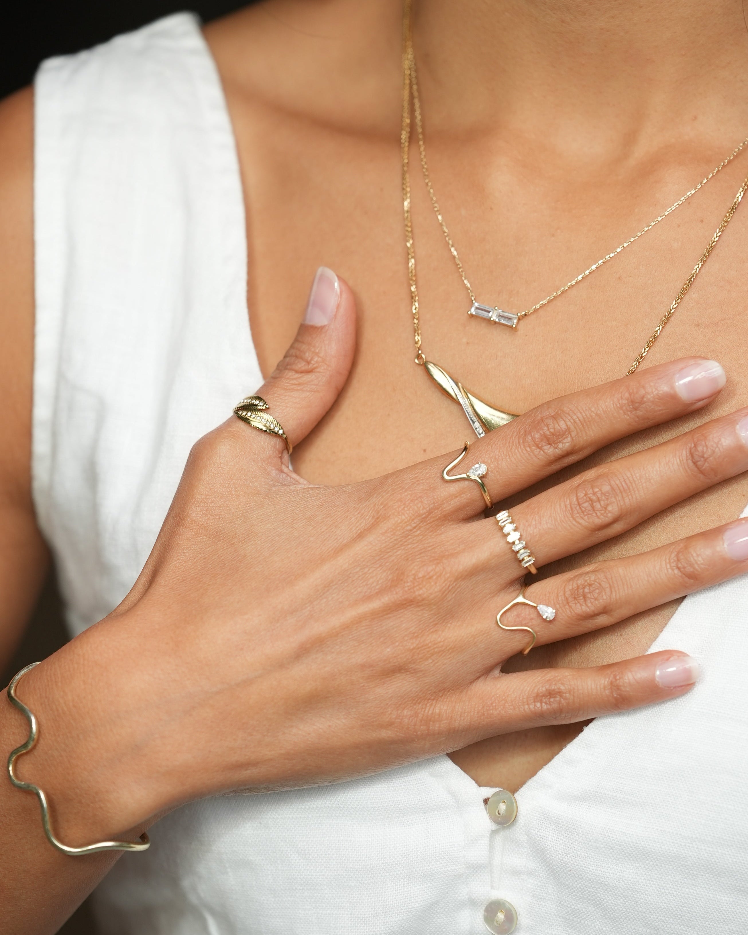 Close-up of a hand with gold jewelry on a white background