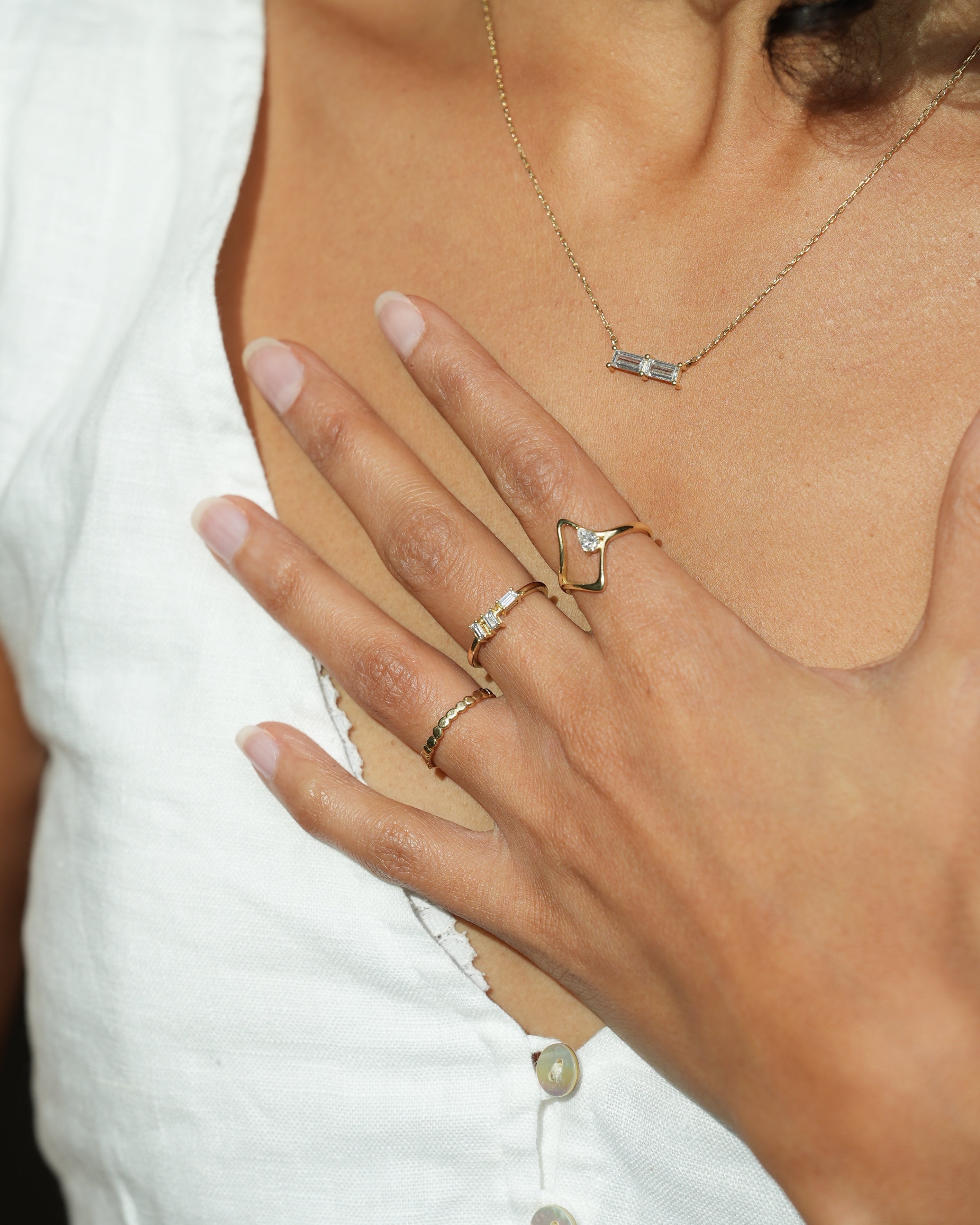 Close-up of a person's hand with multiple rings on a white background