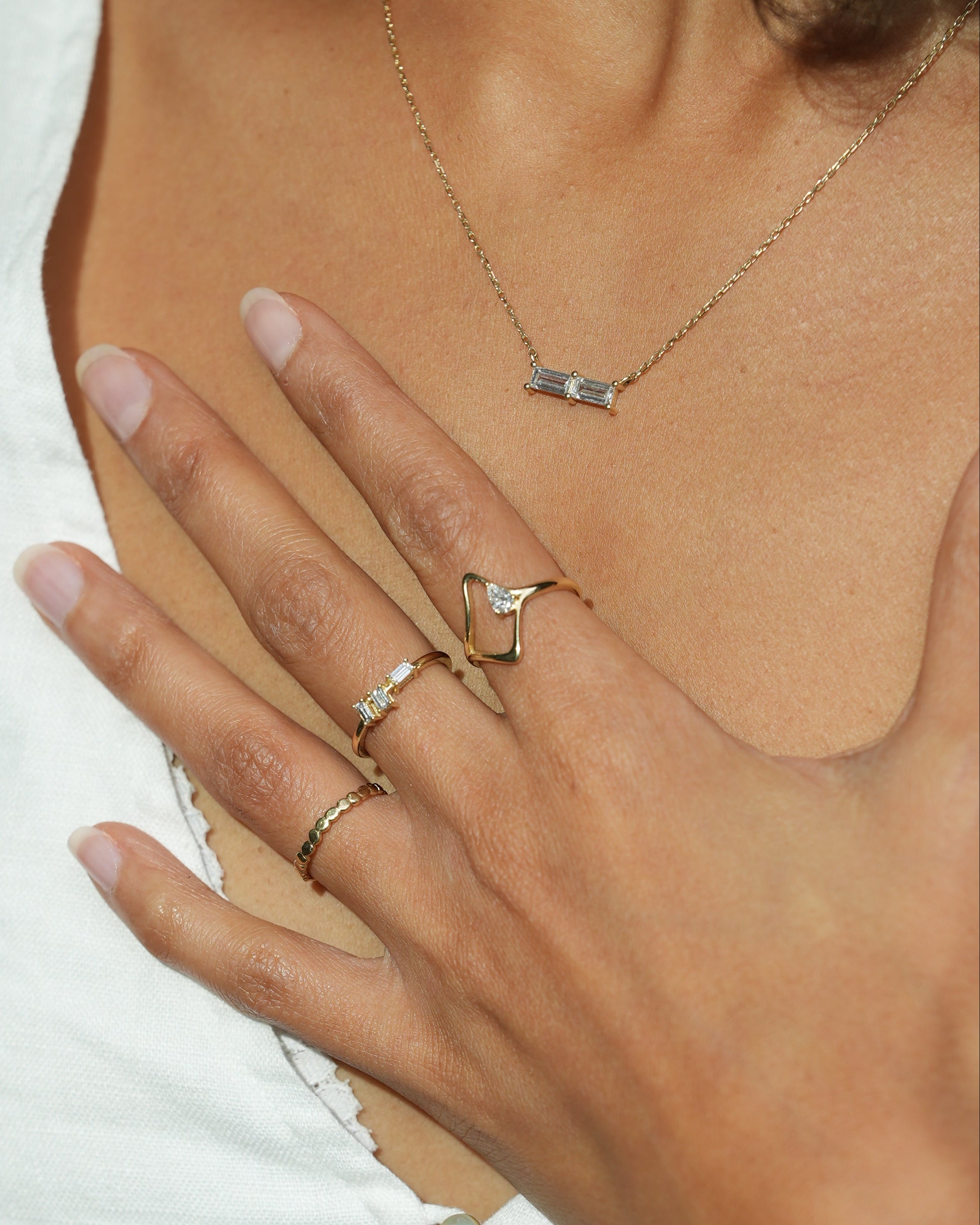 Close-up of a hand wearing multiple rings with a blurred background