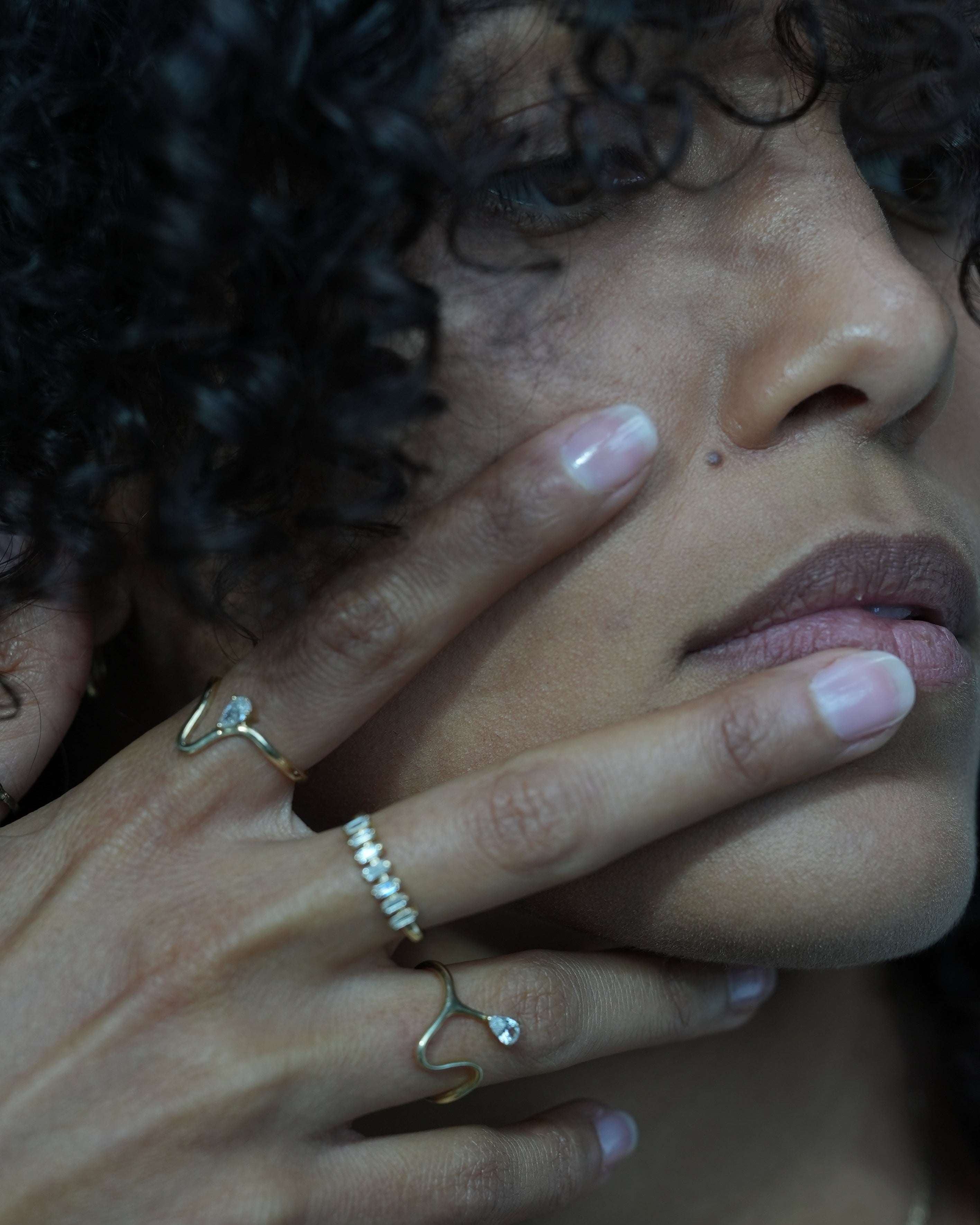 Close-up of a person's hand with rings on a blurred background