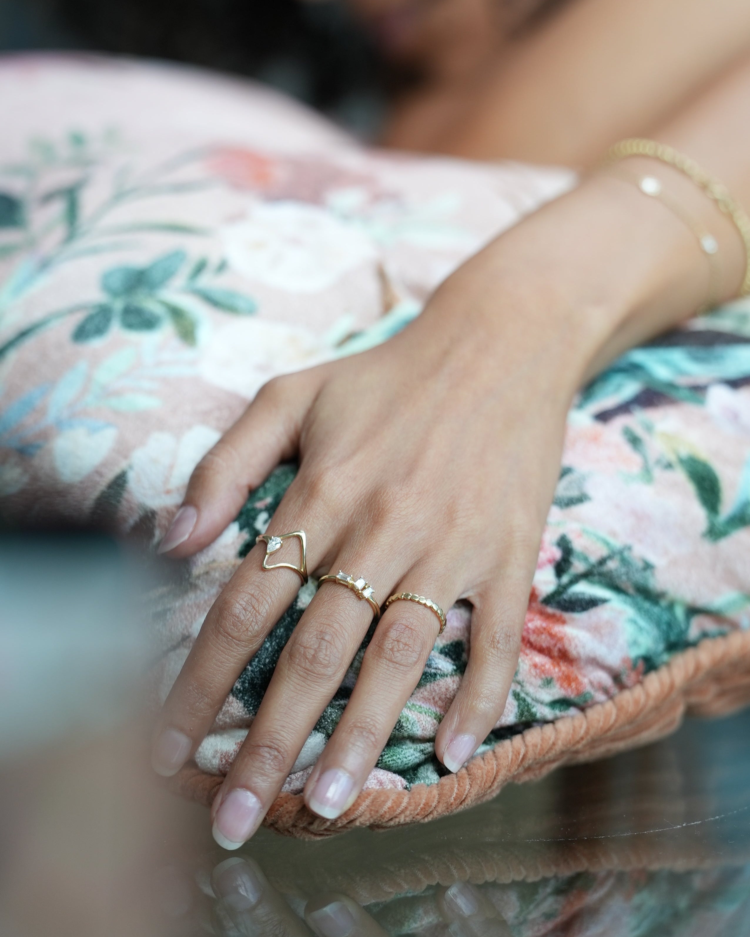 Close-up of a hand with rings holding a woven bag, blurred background