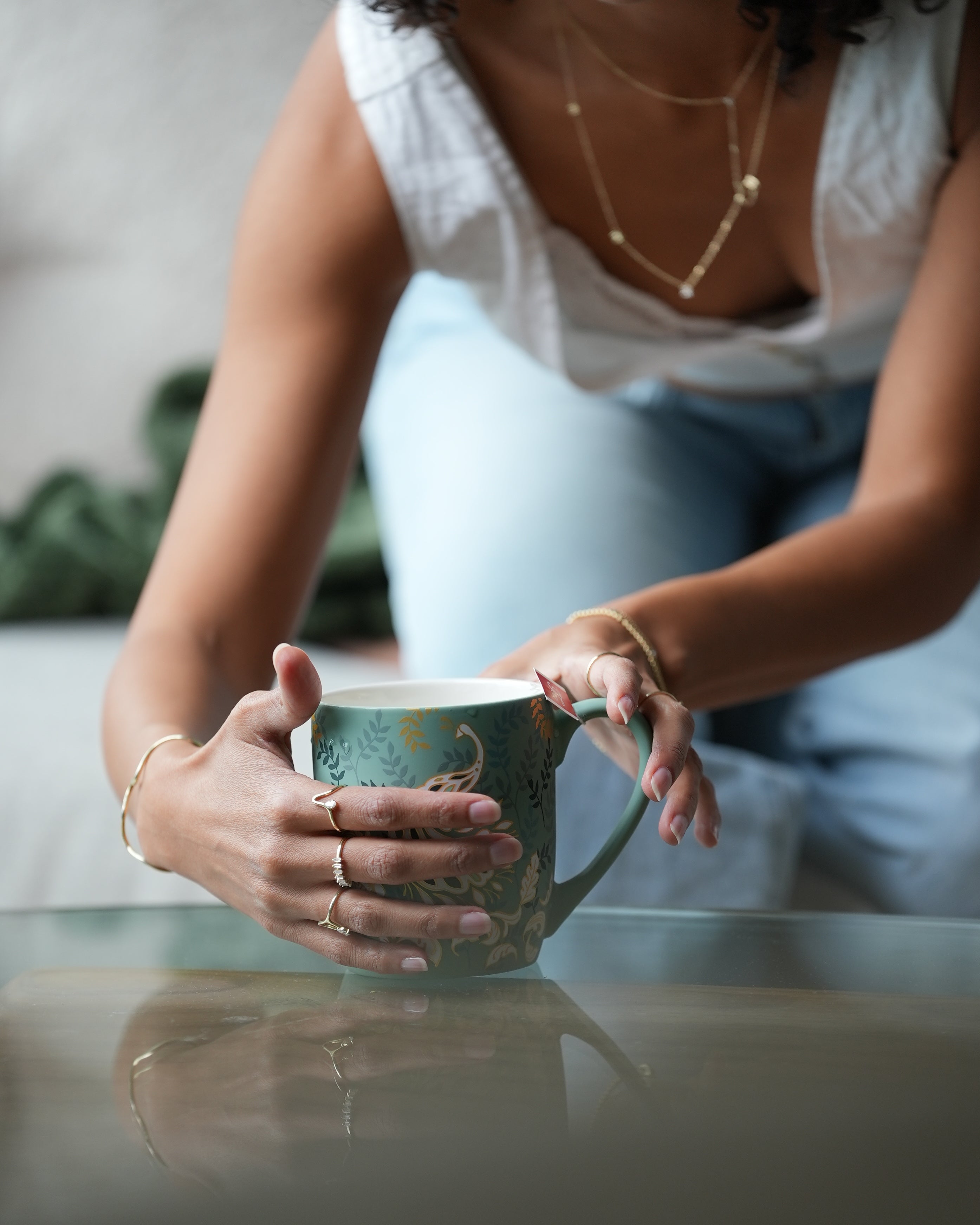 Person holding a small mirror with reflection of another person's hand.