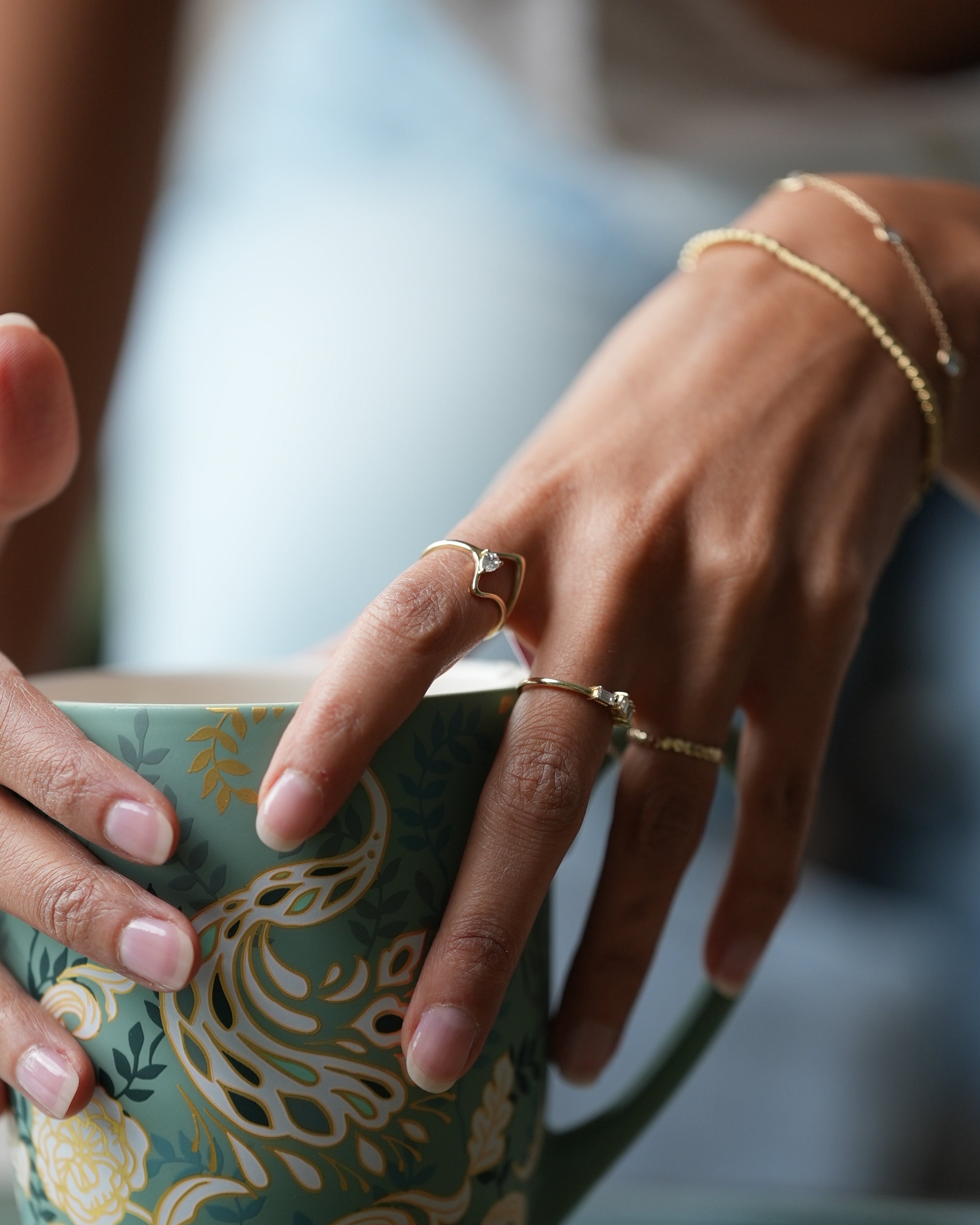 Close-up of a hand holding a decorative box with floral patterns.