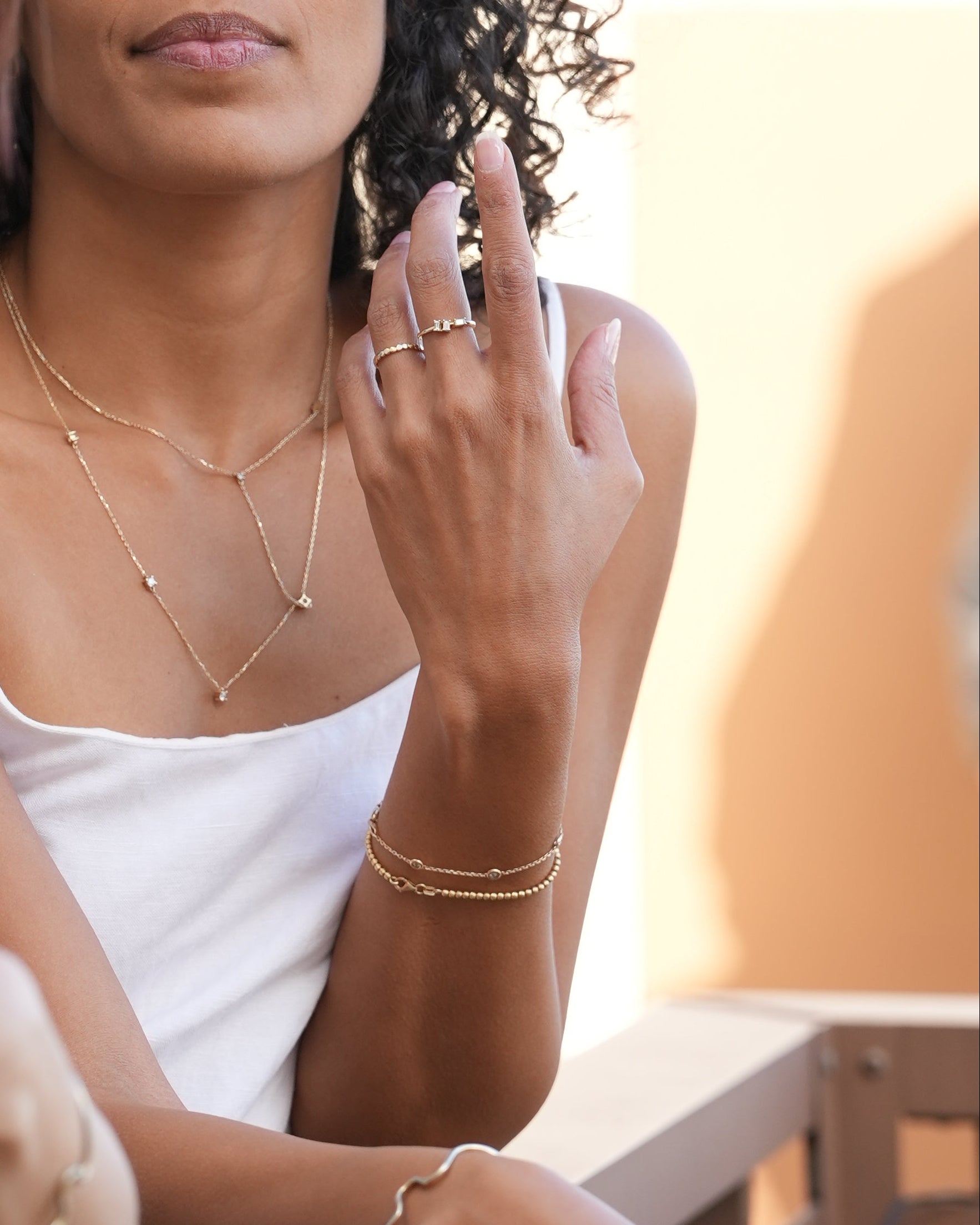Two women embracing each other with a close-up of their hands and faces.