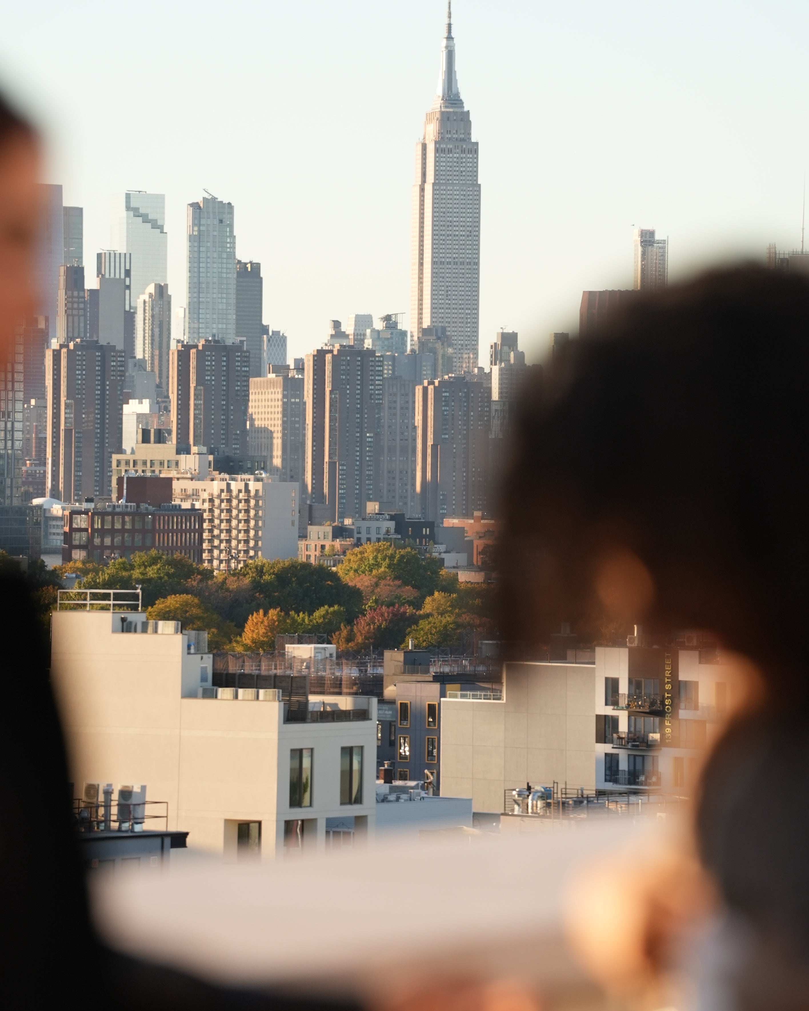 Cityscape with tall buildings and a clear sky, viewed from above.