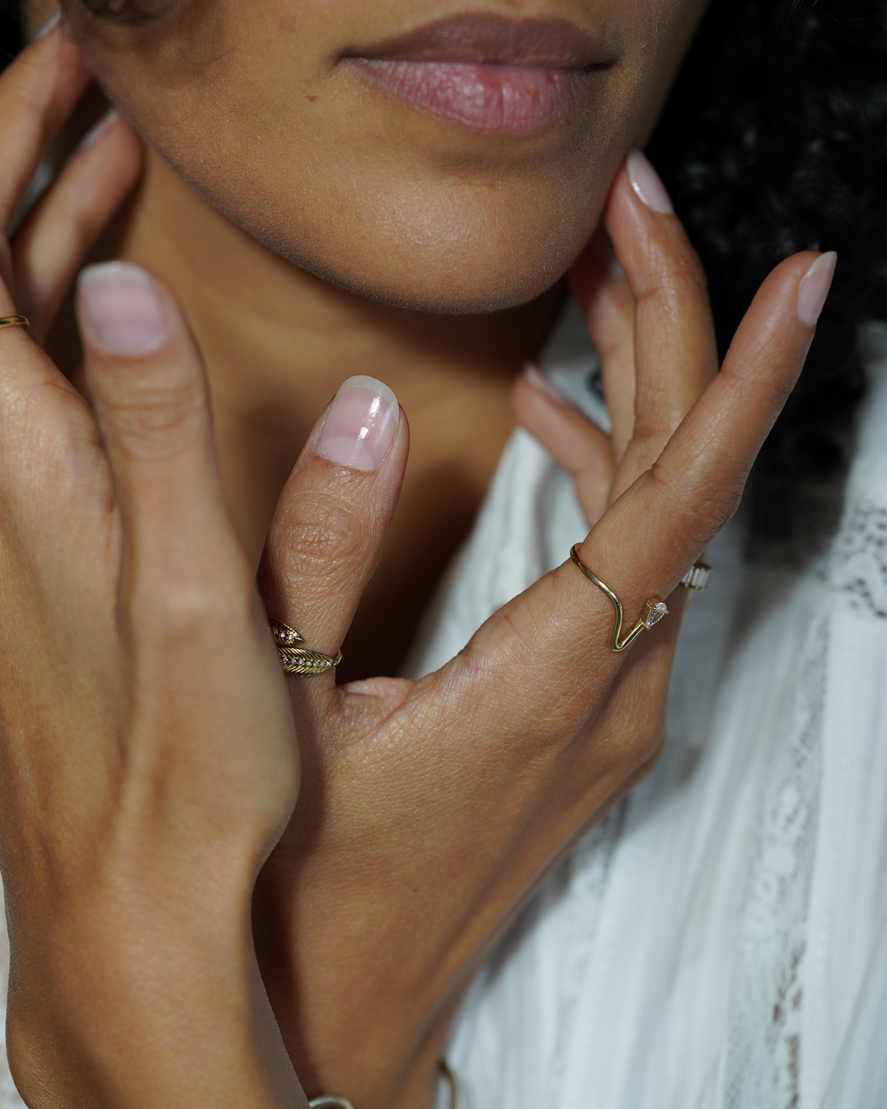Close-up of a person's hands gently touching another person's face.