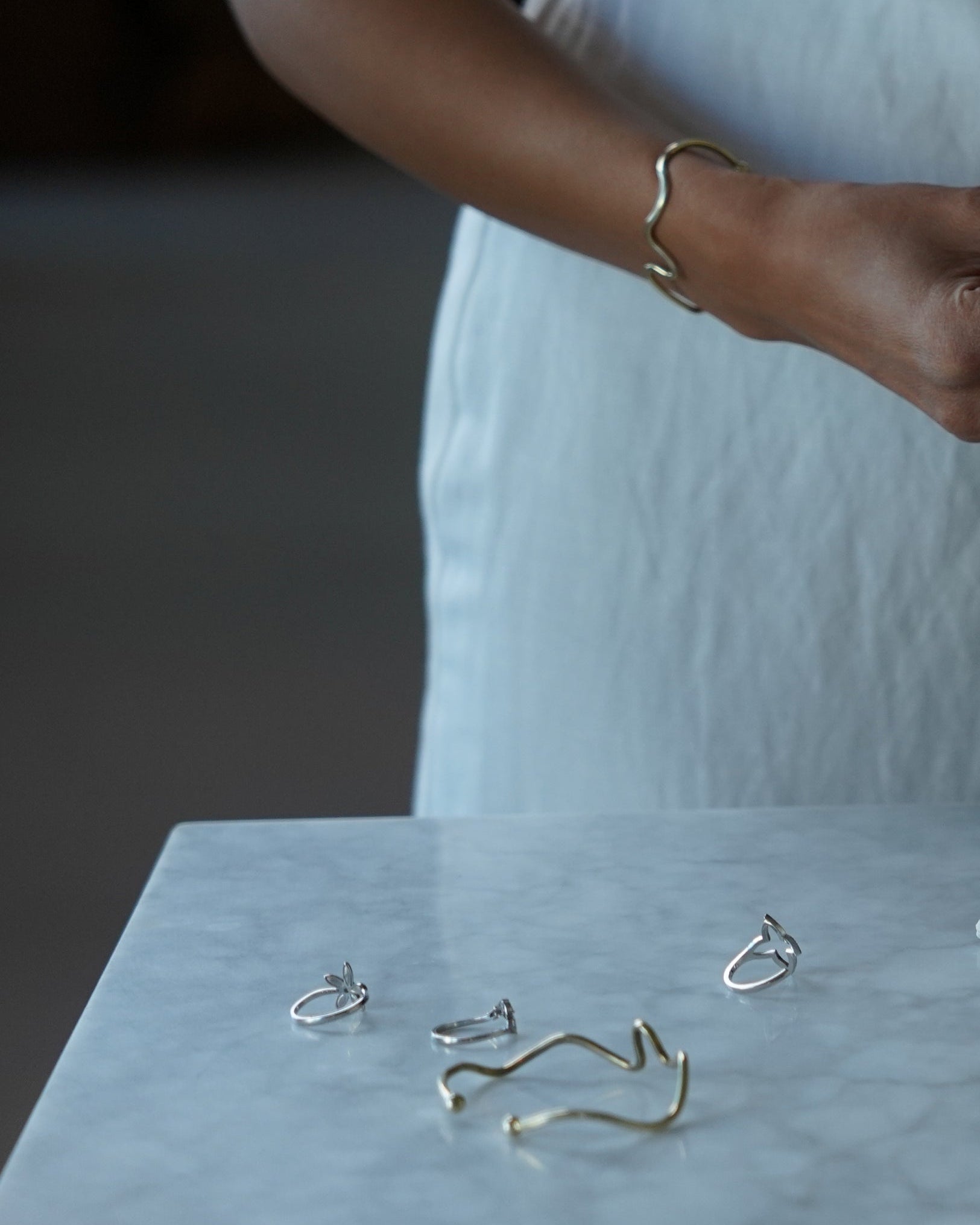 Gold and silver earrings on a light blue surface with a blurred background