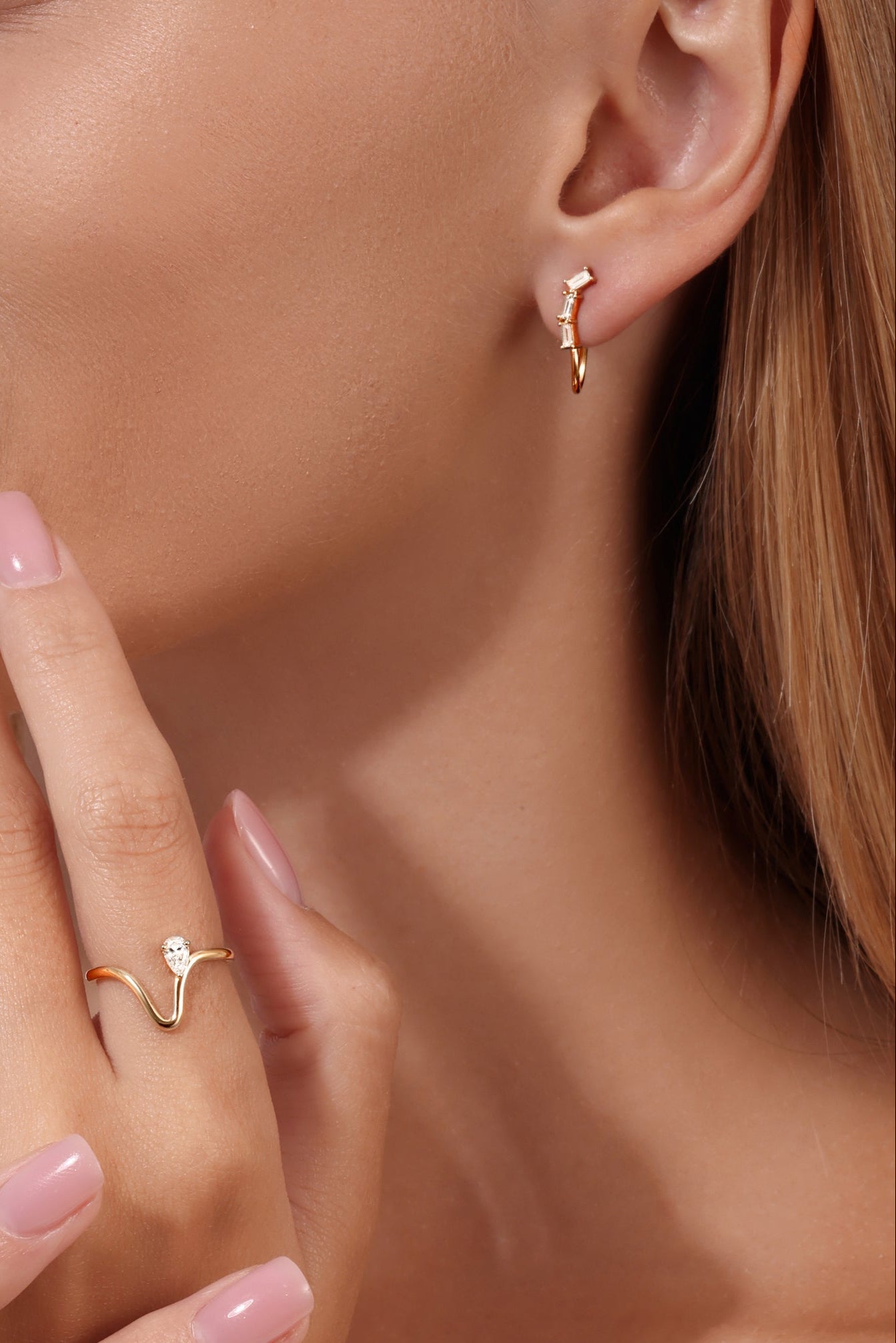 Gold baguette diamond hoop earrings and 14K gold wave ring with pear-shaped diamond