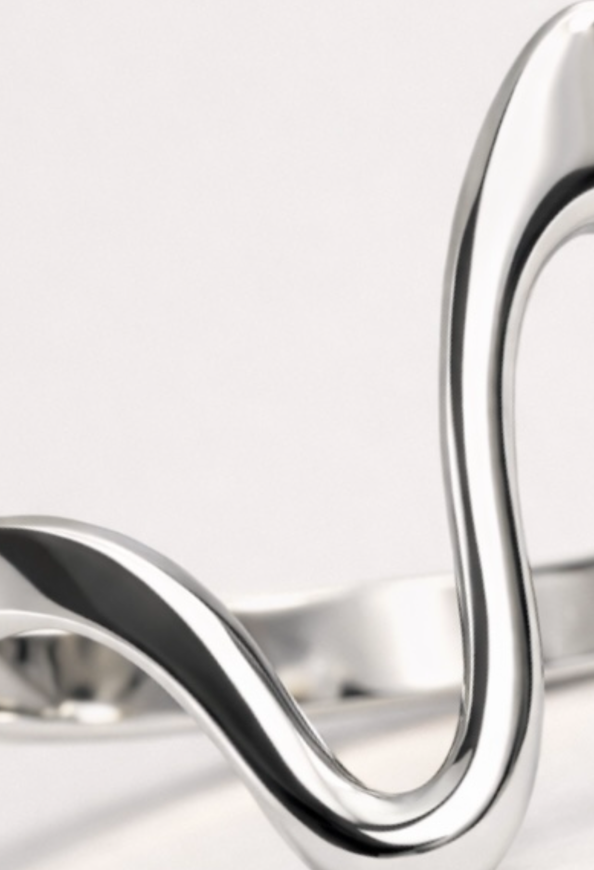 Silver ring with a wavy design on a white background