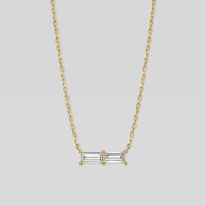 Gold necklace with a rectangular diamond pendant on a light gray background