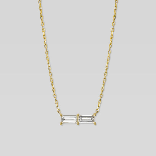 Gold necklace with a rectangular diamond pendant on a light gray background