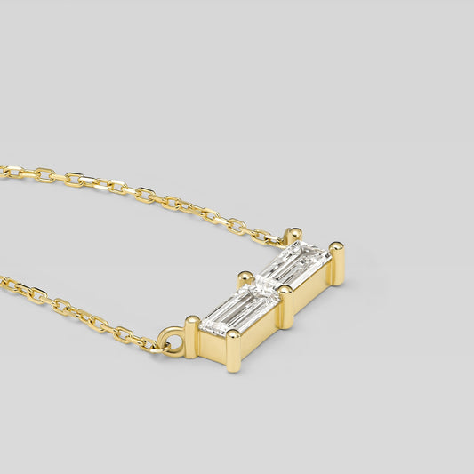 Gold necklace with a rectangular diamond pendant on a light gray background