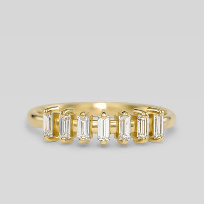 Gold ring with baguette-cut diamonds on a light gray background