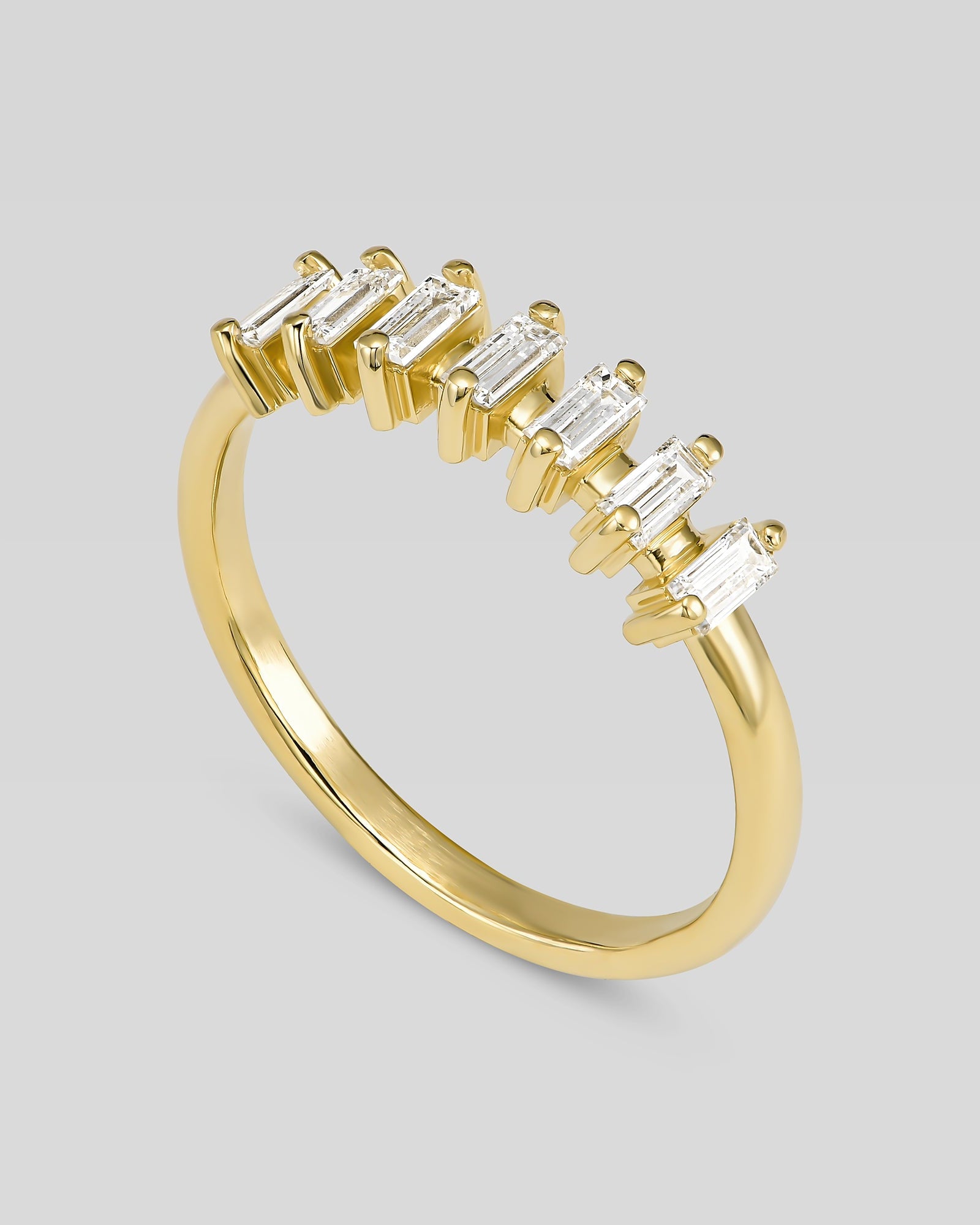 Gold ring with baguette-cut diamonds on a light gray background