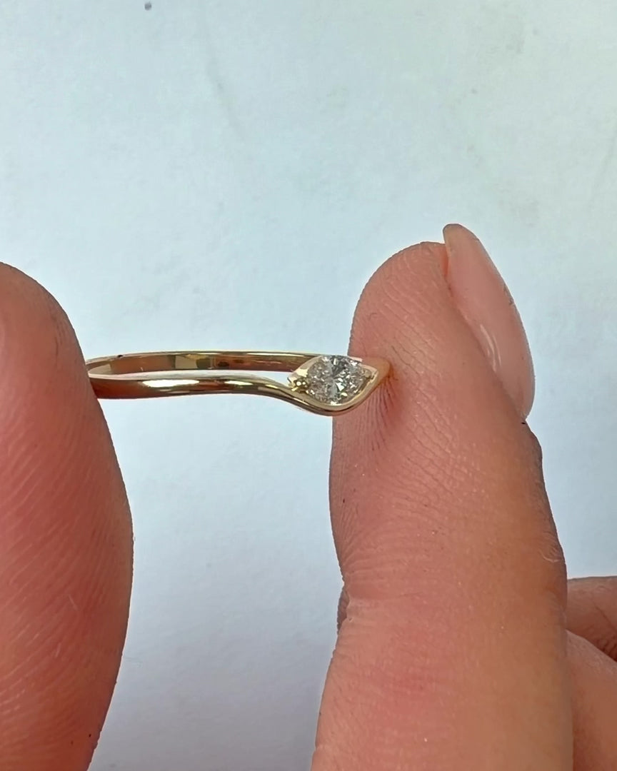 Motion 0.10, Motion 0.10 ct ring in 14K gold with a lab grown marquise diamond, held between the fingers